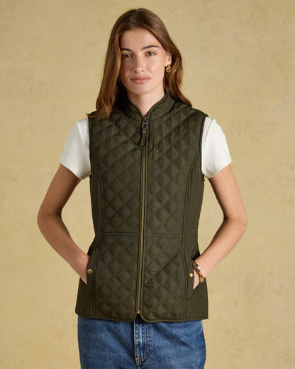 Green coloured Joules Womens Minx Showerproof Diamond Quilted Gilet on a gold background 
