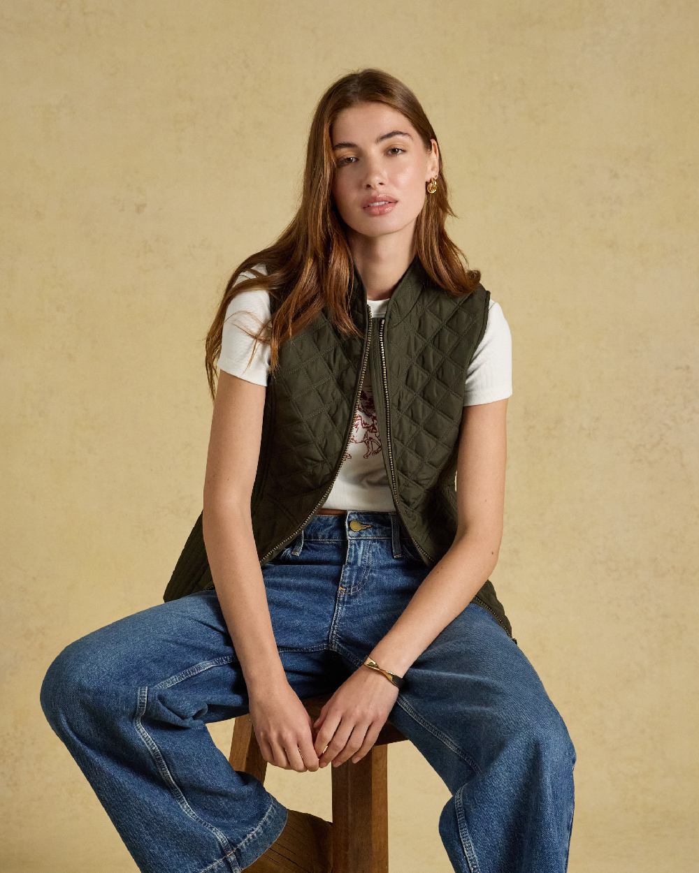 Green coloured Joules Womens Minx Showerproof Diamond Quilted Gilet on a gold background 