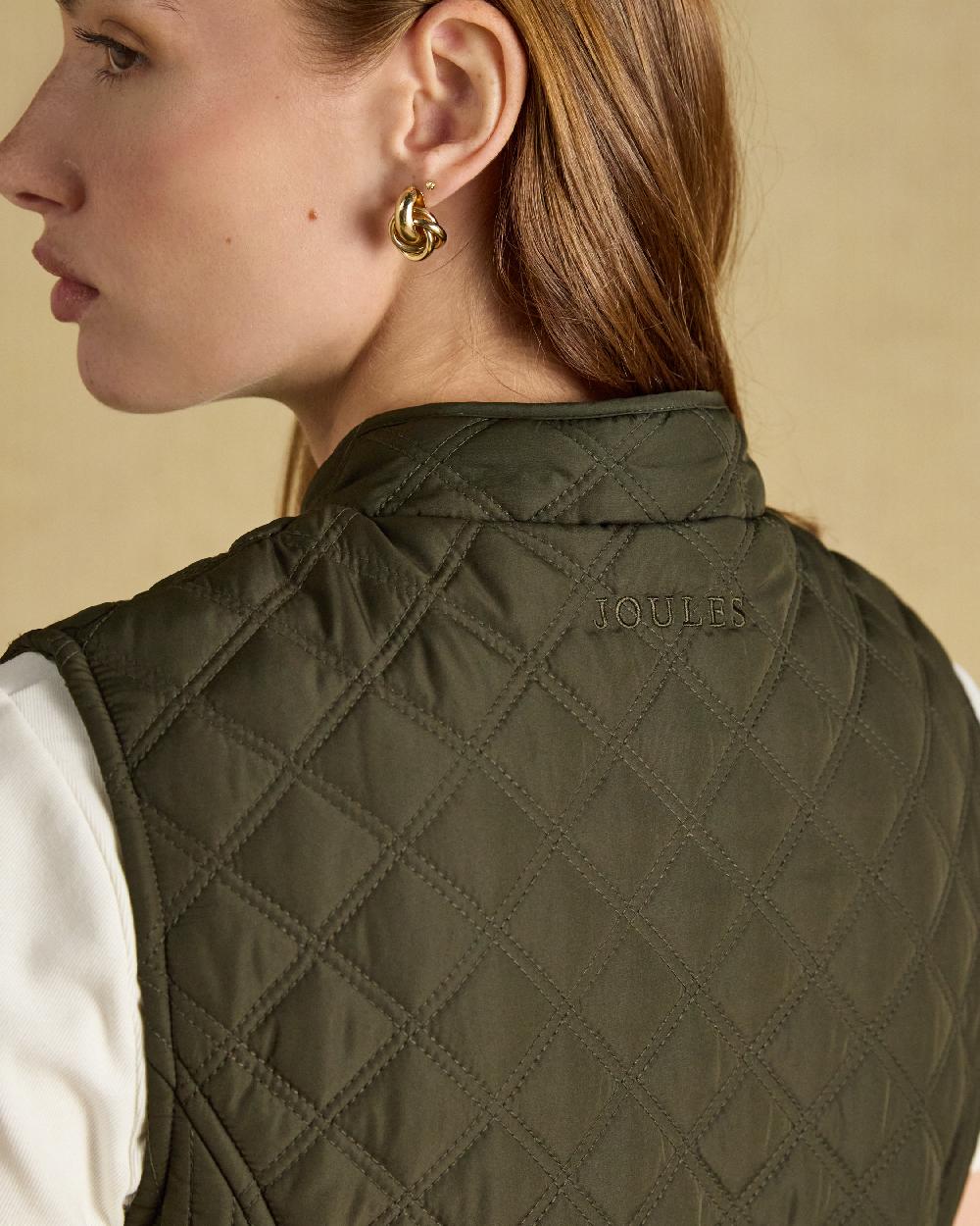 Green coloured Joules Womens Minx Showerproof Diamond Quilted Gilet on a gold background 