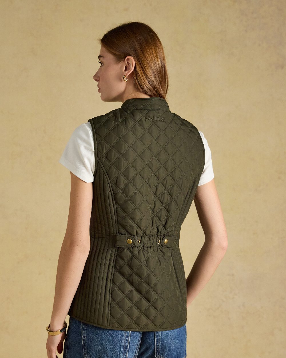 Green coloured Joules Womens Minx Showerproof Diamond Quilted Gilet on a gold background 