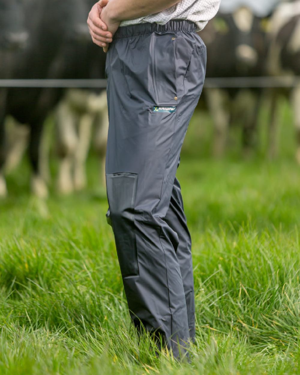 Navy coloured Kaiwaka Mens AgTex Overtrousers on grassy background 