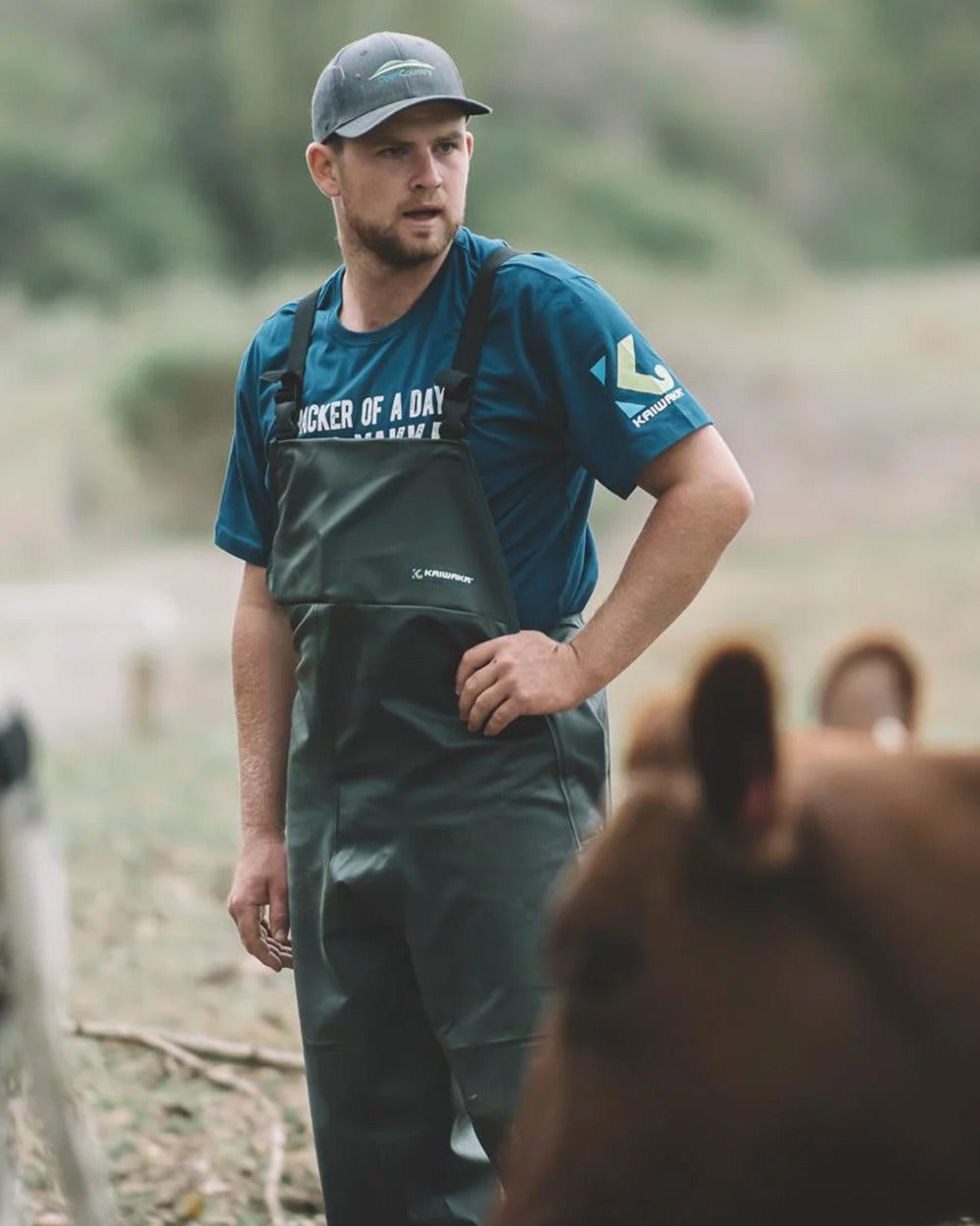 Green coloured Kaiwaka Mens Dairytex Bib Overtrousers on forest background 