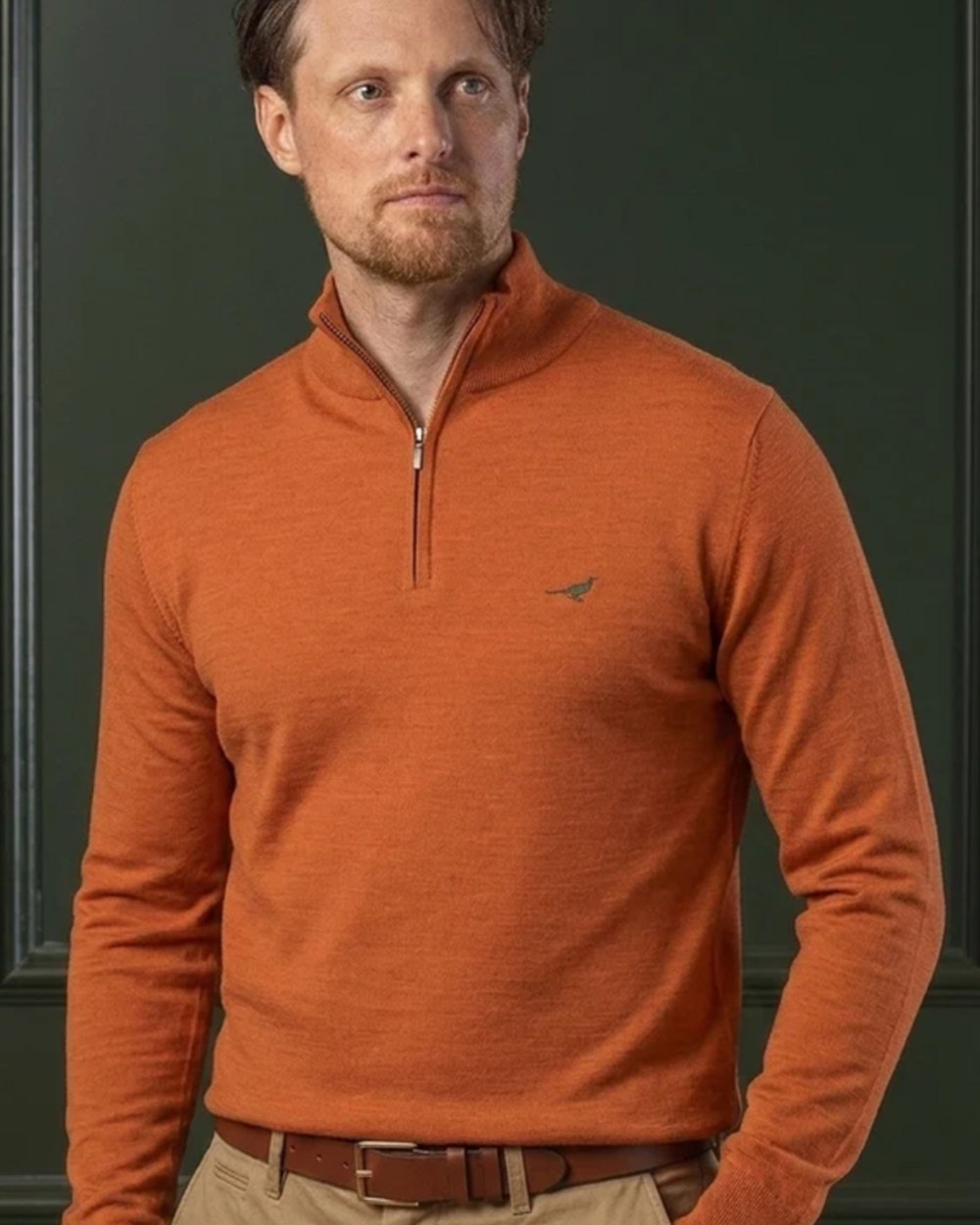 Orange Coloured Laksen Norfolk Zip Neck Merino Sweater on indoor background 