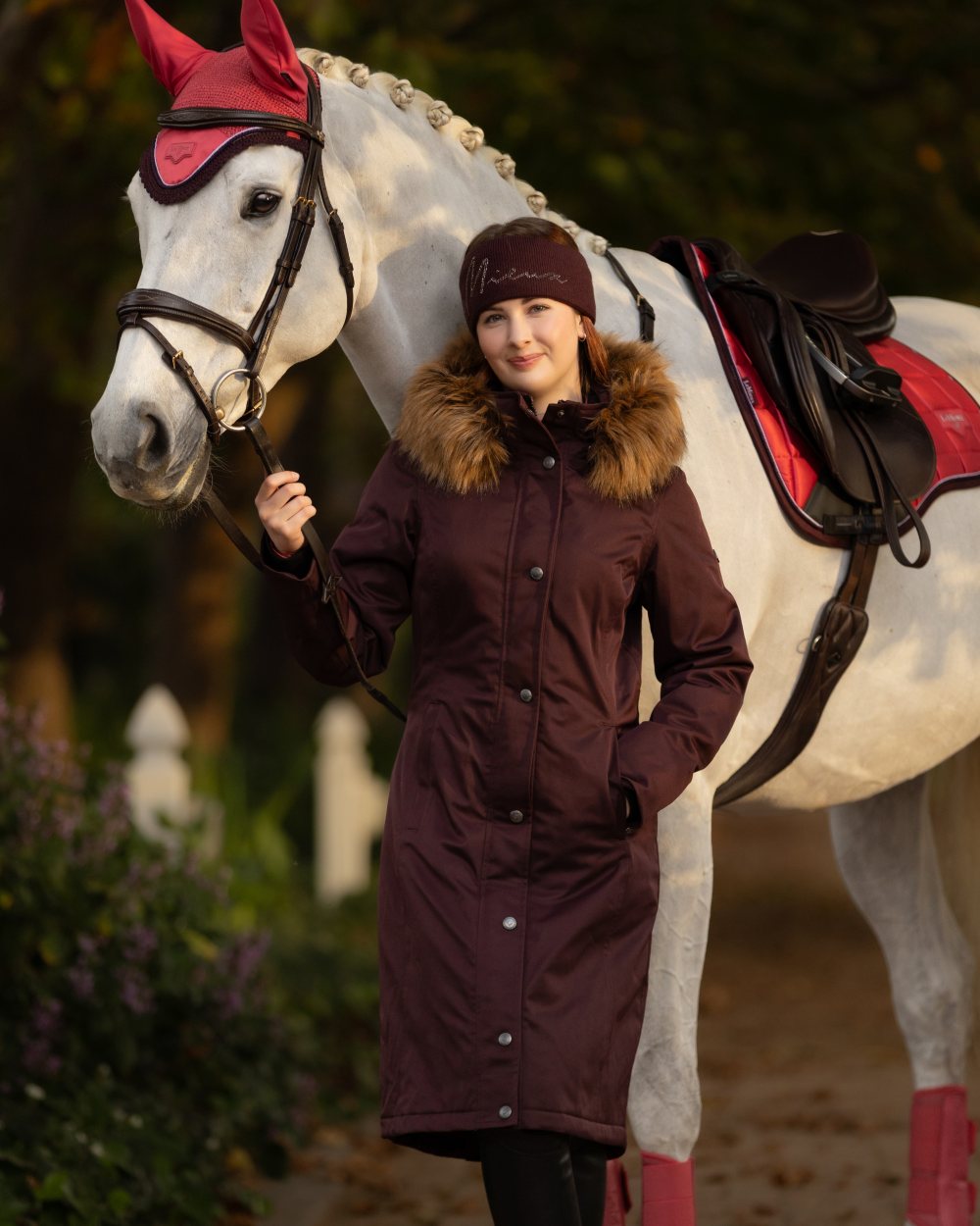 Damson Coloured LeMieux Anya Waterproof Riding Coat On A Tree Background 