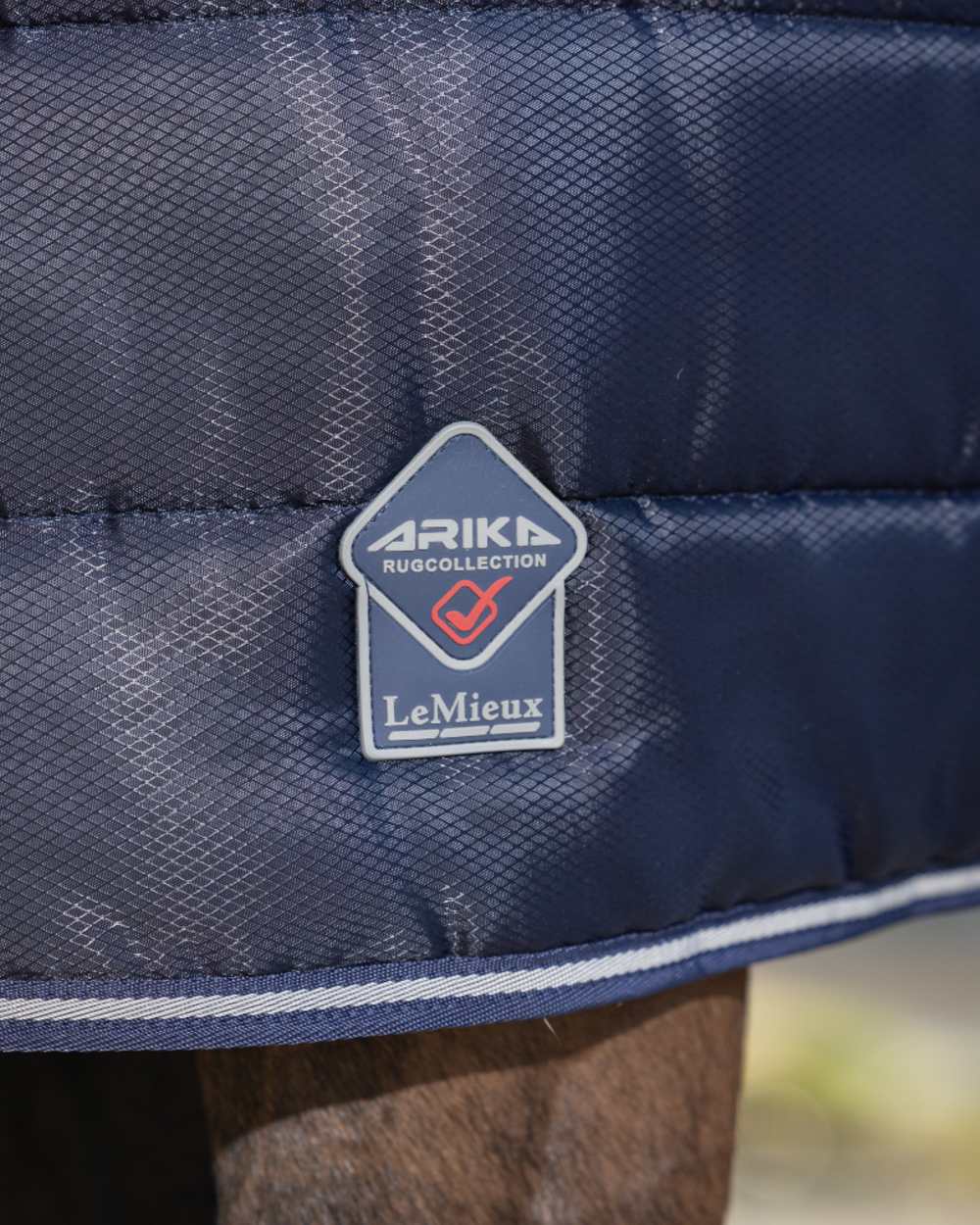 Navy coloured LeMieux Arika Stable-Tek 100g on outdoor background 