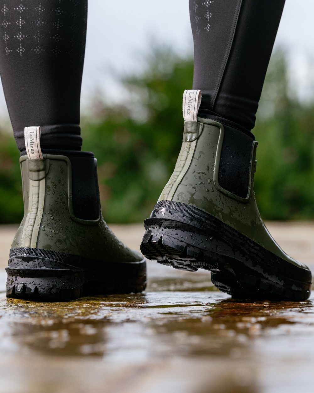 Olive coloured LeMieux Bramshaw Chelsea Wellies on water background 