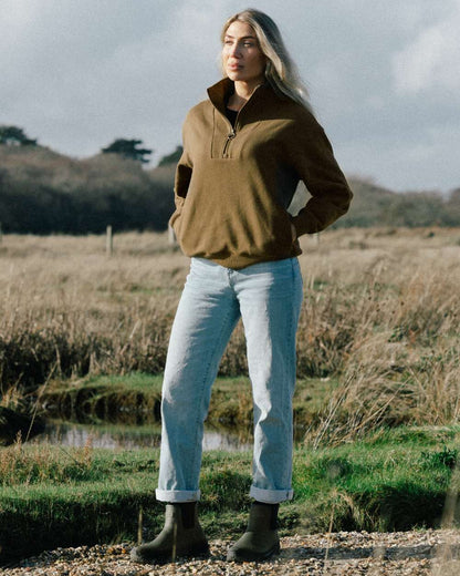 Olive coloured LeMieux Bramshaw Chelsea Wellies on soil background 