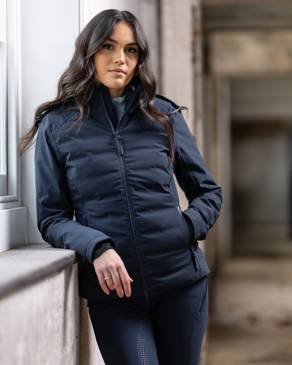 Navy coloured LeMieux Brooke Waterproof Hybrid Jacket on window background 