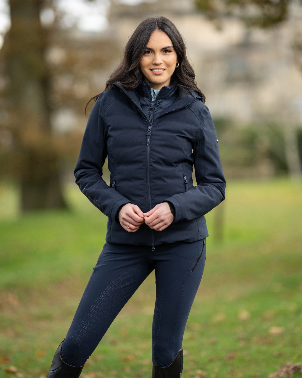 Navy coloured LeMieux Brooke Waterproof Hybrid Jacket on blurry background 