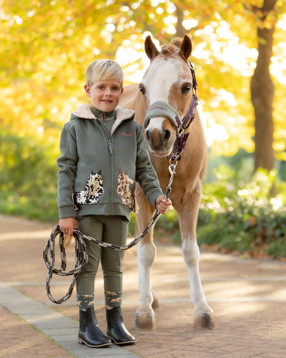 Rosemary coloured LeMieux Childrens Mini Charlie Pony Hoodie on tree background 