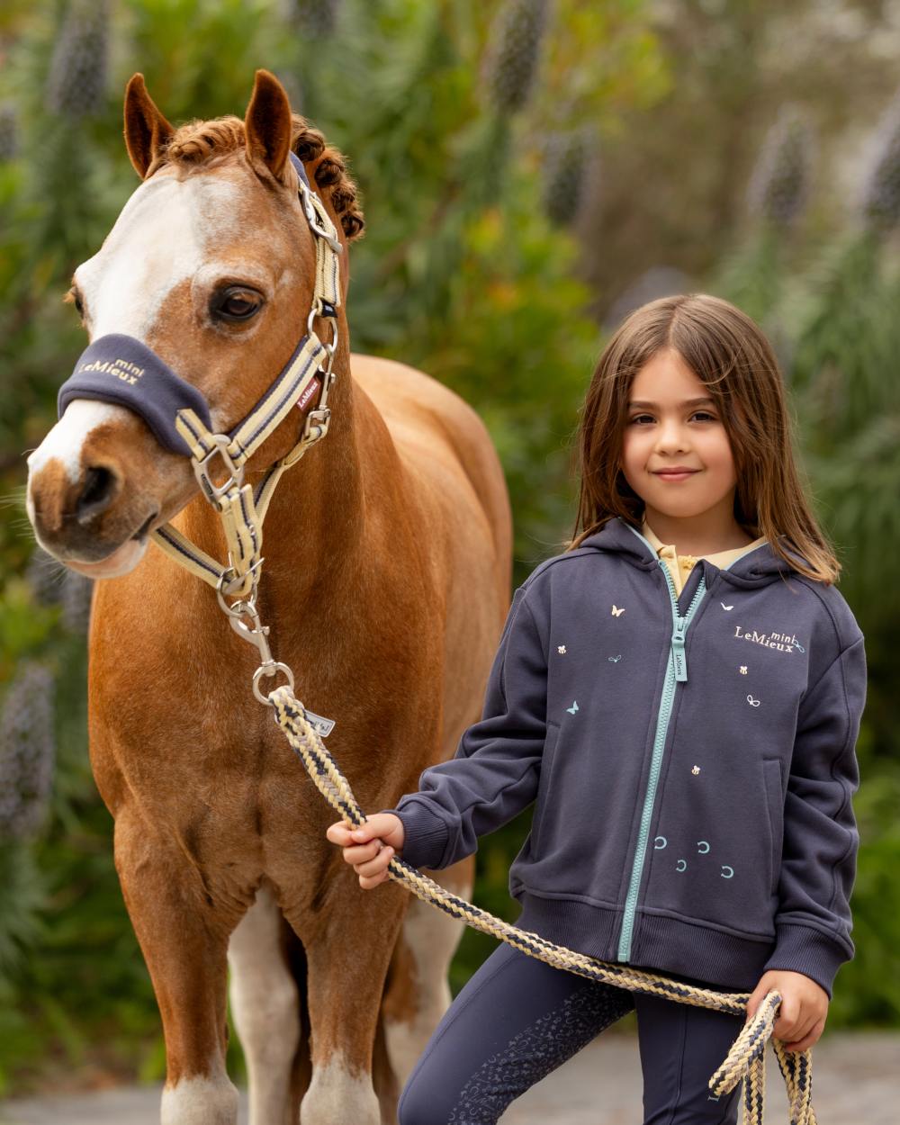 Dusk Blue coloured LeMieux Childrens Mini Charlie Zip Through Hoodie on backyard background 