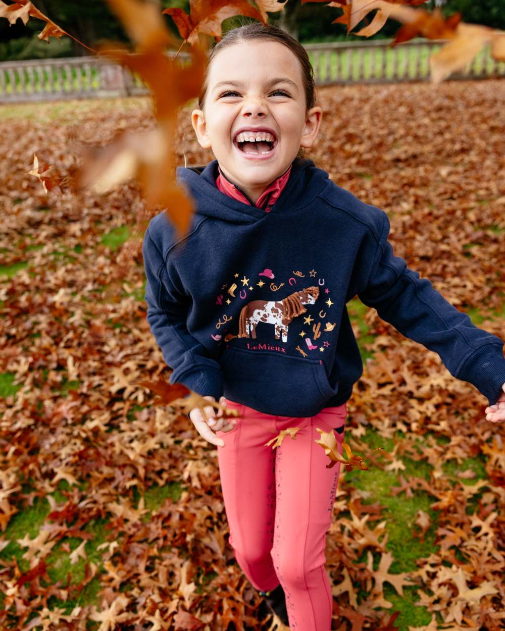 Navy coloured LeMieux Childrens Mini Romi Hoodie on leafy background 