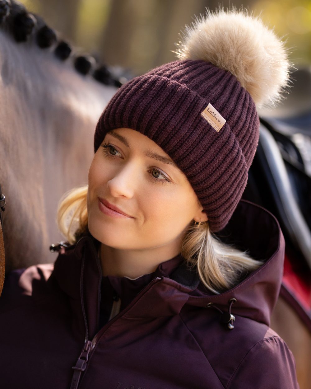 Damson coloured LeMieux Clara Rib Beanie on blurry background 