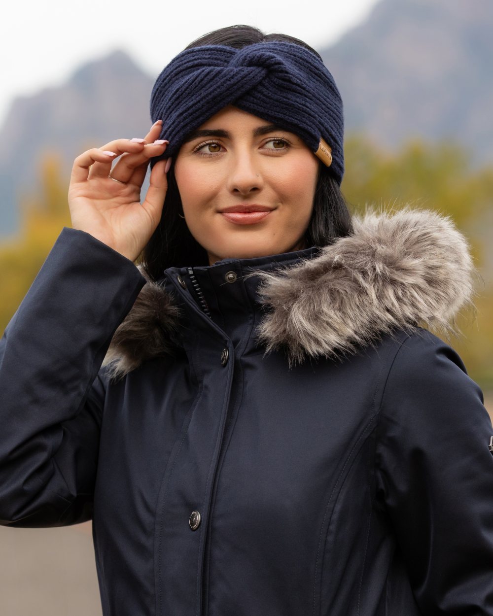 Navy coloured LeMieux Clara Rib Knot Headband on mountain background 