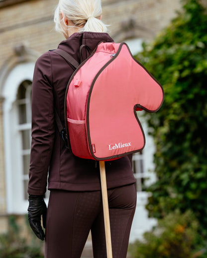 Cranberry coloured LeMieux Hobby Horse Carry Bag on outdoor background 
