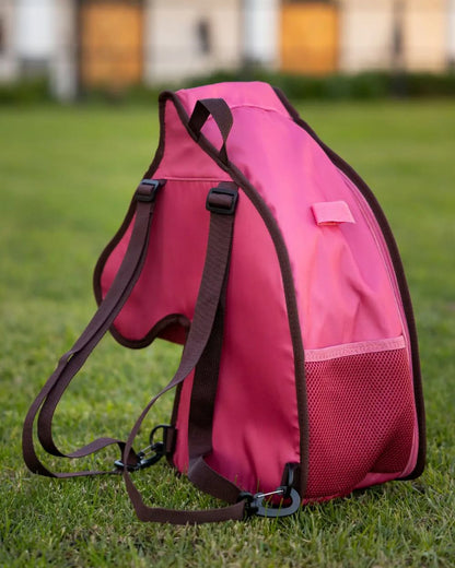 Cranberry coloured LeMieux Hobby Horse Carry Bag on garden background 