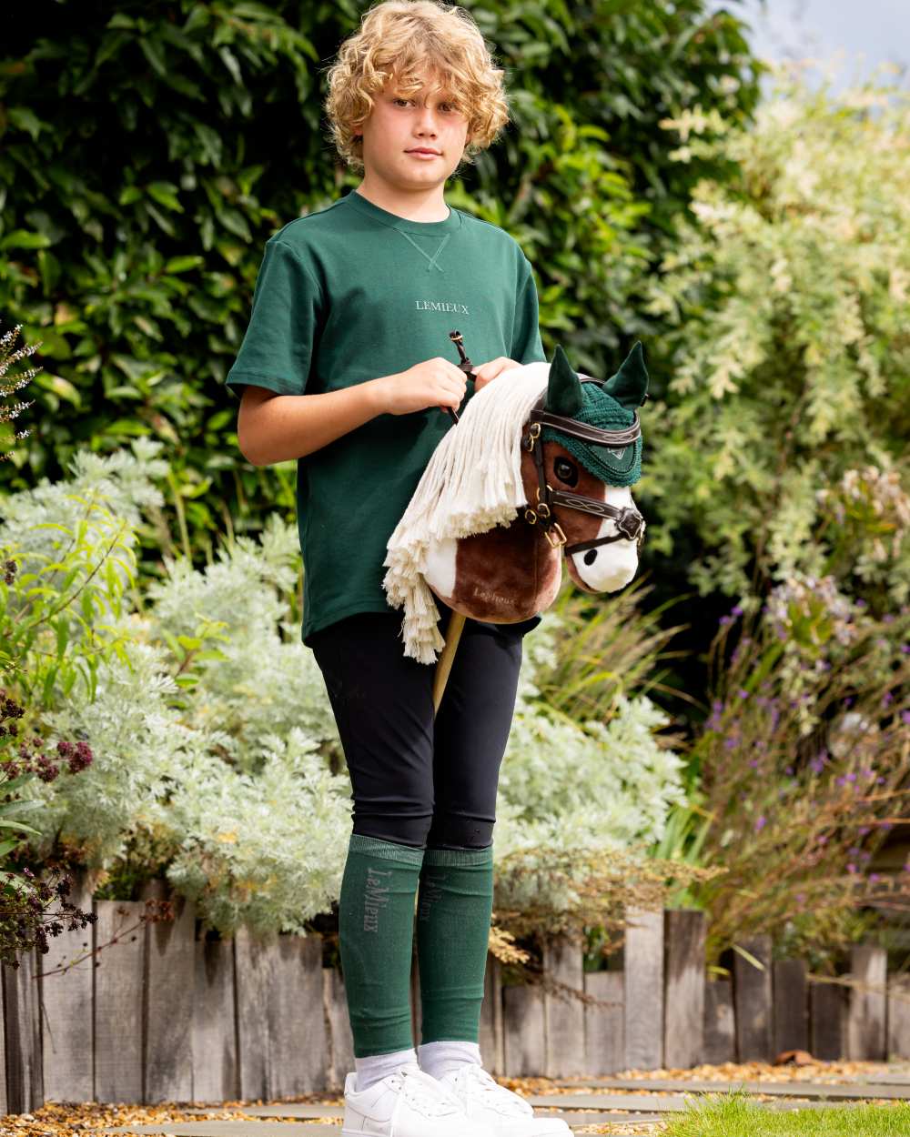 Brown coloured LeMieux Hobby Horse Grackle Bridle on tree background 