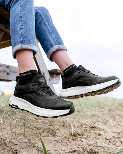 Black coloured LeMieux Womens Kanta Waterproof Trainers on beach background 