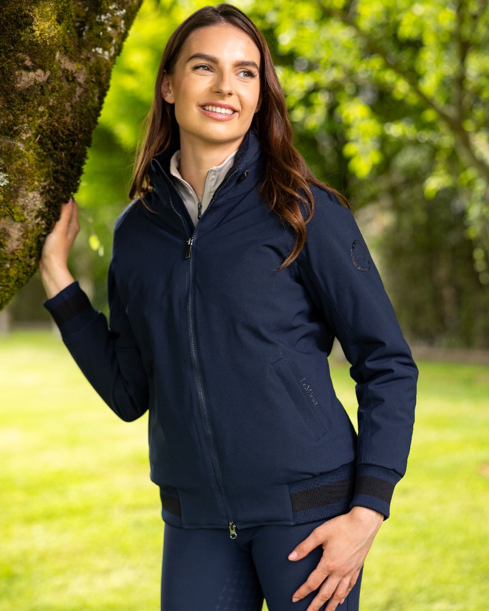 Navy coloured LeMieux Ladies Team Jacket on lawn background 