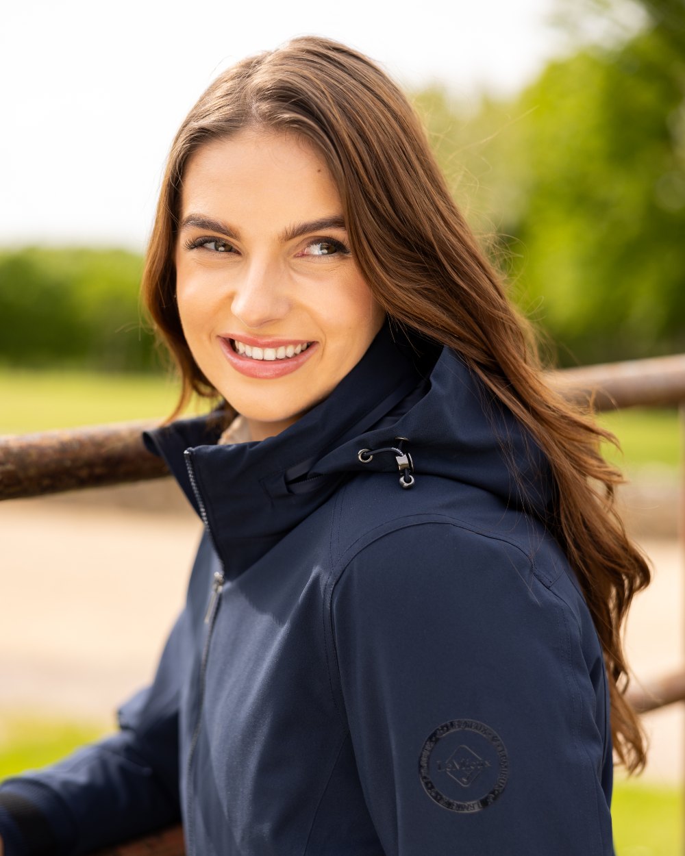 Navy coloured LeMieux Ladies Team Jacket on lawn background 
