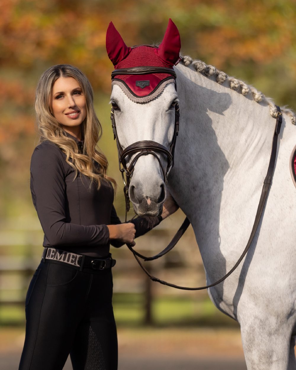 Ember coloured LeMieux Loire Fly Hood on blurry background 