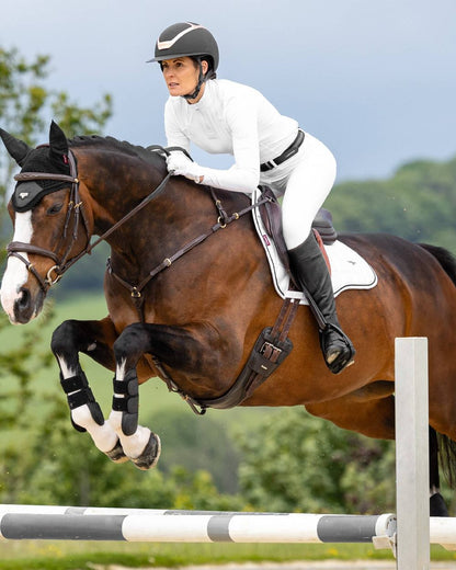 White coloured LeMieux Loire GP Square Pad on riding arena background 