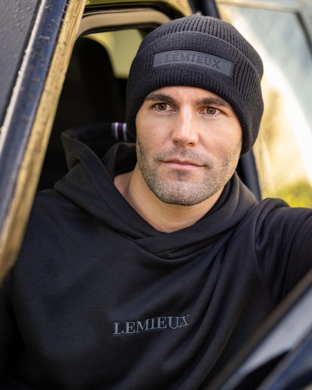 Black coloured LeMieux Mens Beanie on outdoor background 