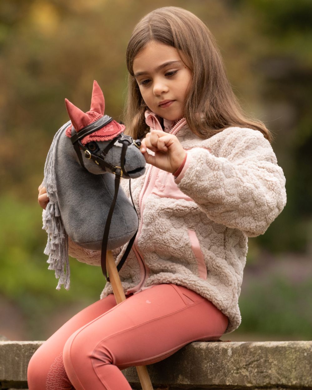 Smokey coloured LeMieux Mini Hobby Horse Smokey on outdoor background 