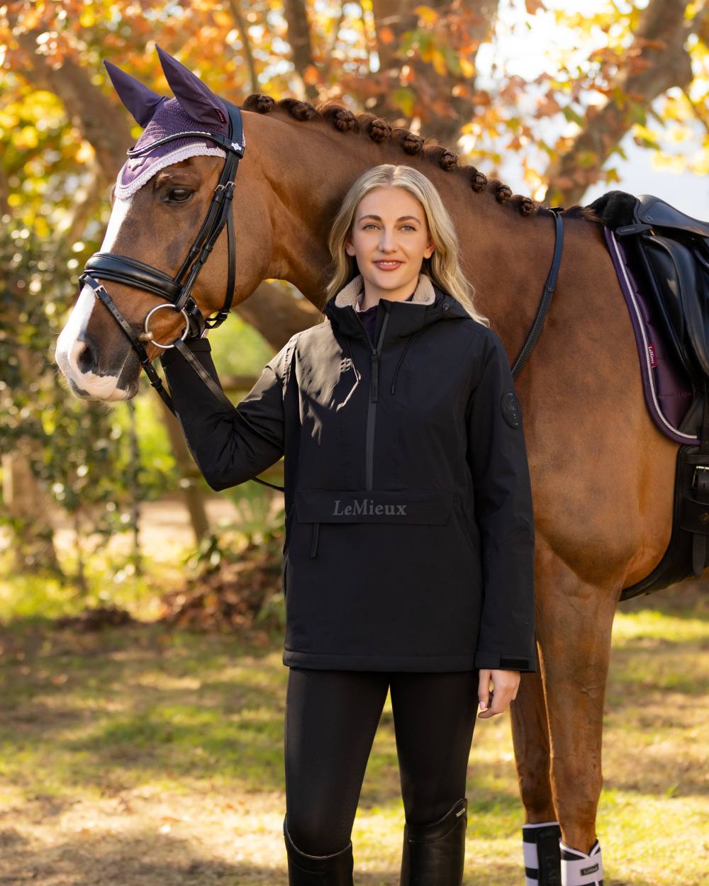 Black coloured LeMieux Phoebe Half Zip Waterproof Anorak on tree background 