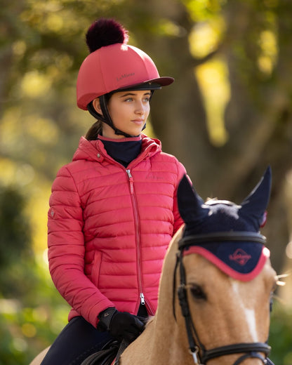 Cranberry coloured LeMieux Classique Pom Hat Silk on blurry background 