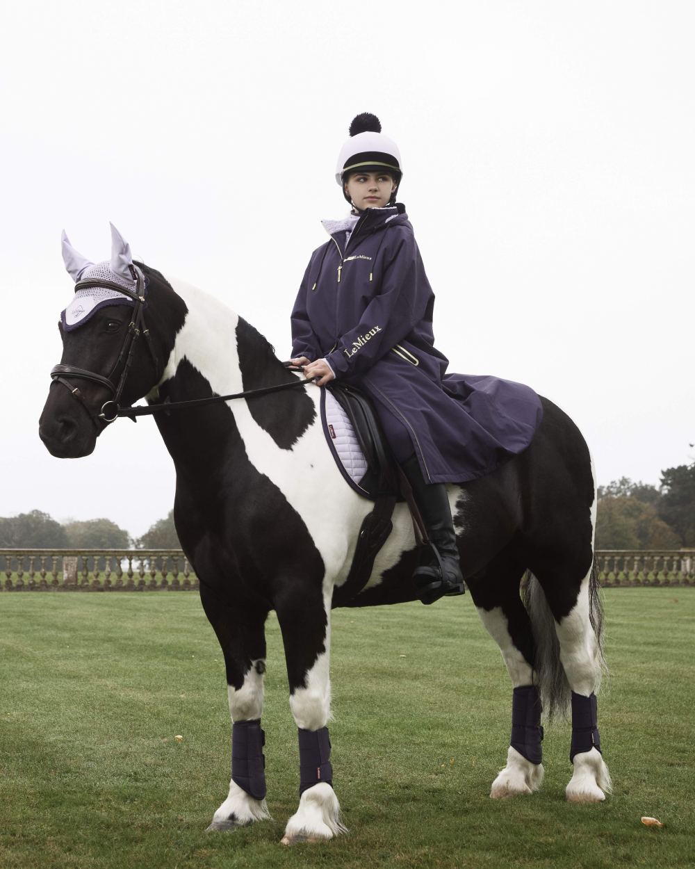 Lilac coloured LeMieux Pom Hat Silk on farm background 
