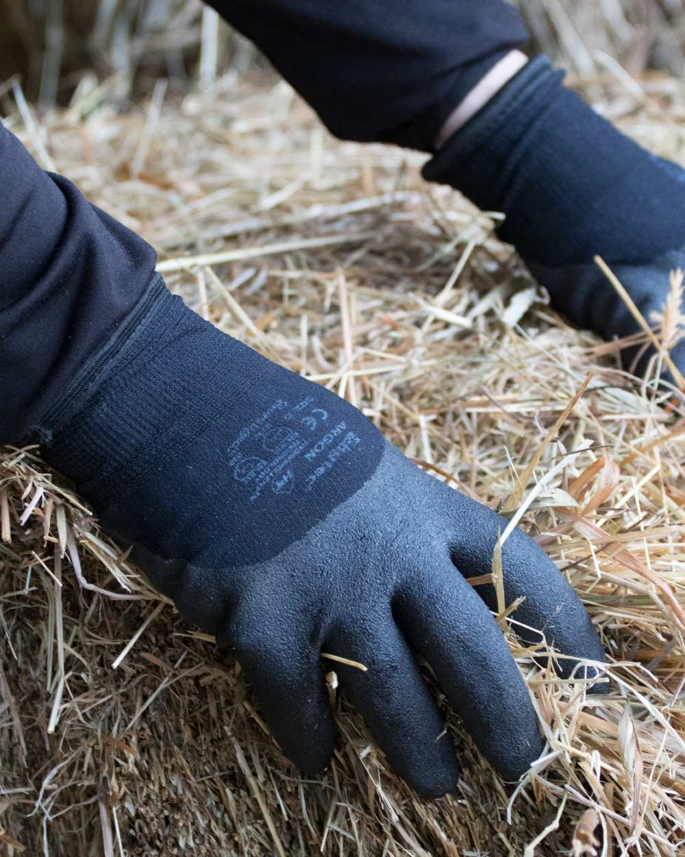 Black coloured LeMieux Thermal Work Gloves on grassy background 