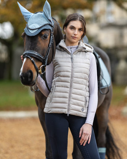 Ash coloured LeMieux Tilly Hooded Puffer Gilet on blurry background 