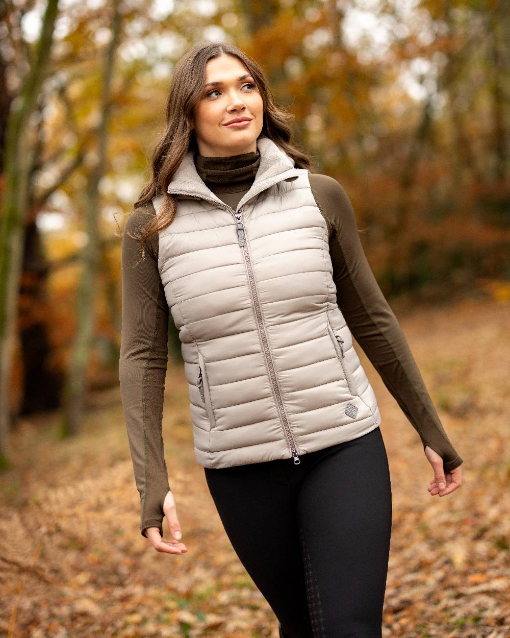 Ash coloured LeMieux Tilly Hooded Puffer Gilet on blurry background 