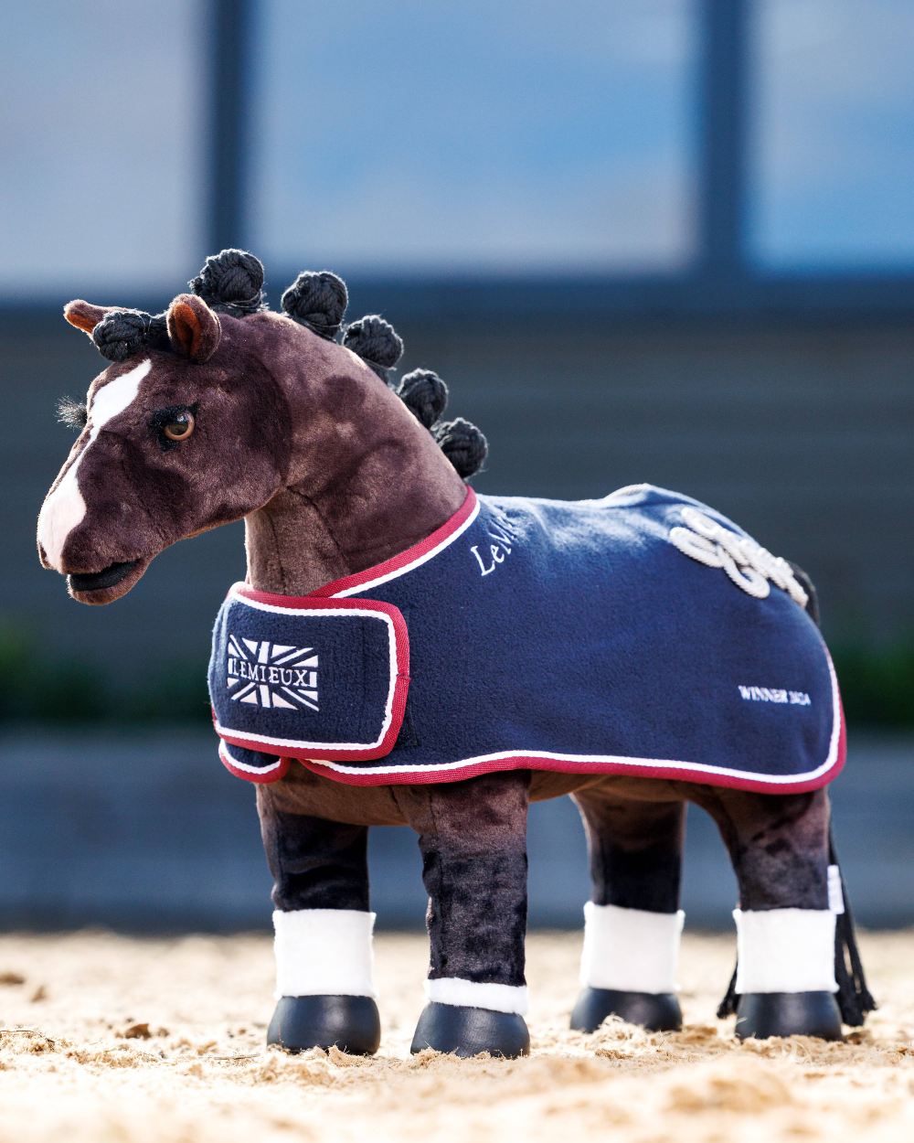 Navy coloured LeMieux Toy Pony Winners Rug on blurry background 