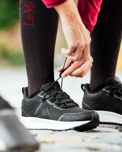 Black coloured LeMieux Trax Sports Waterproof Trainers on blurry background 