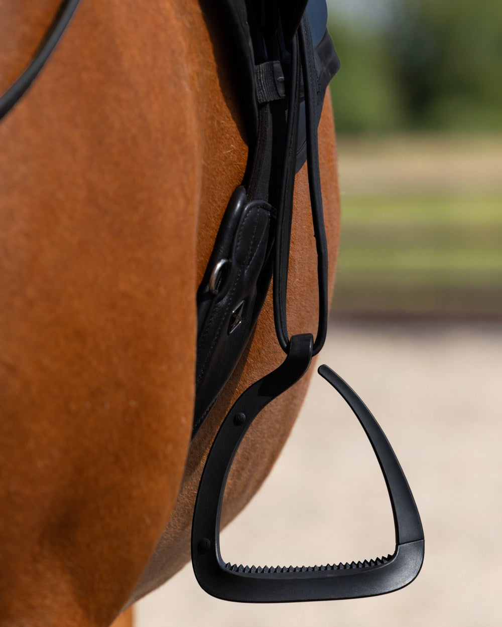 Black coloured LeMieux VectorFlex Stirrup Arm on outdoor background 