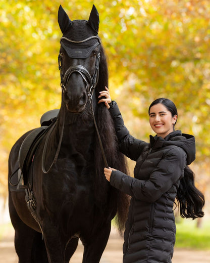 Black coloured LeMieux Womens Hayley Water Resistant Longline Puffer Coat on tree background 