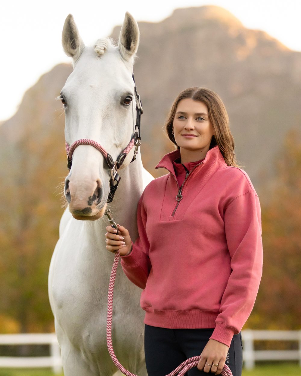 Cranberry coloured LeMieux Womens Keira Quarter Neck Sweatshirt on mountain background 