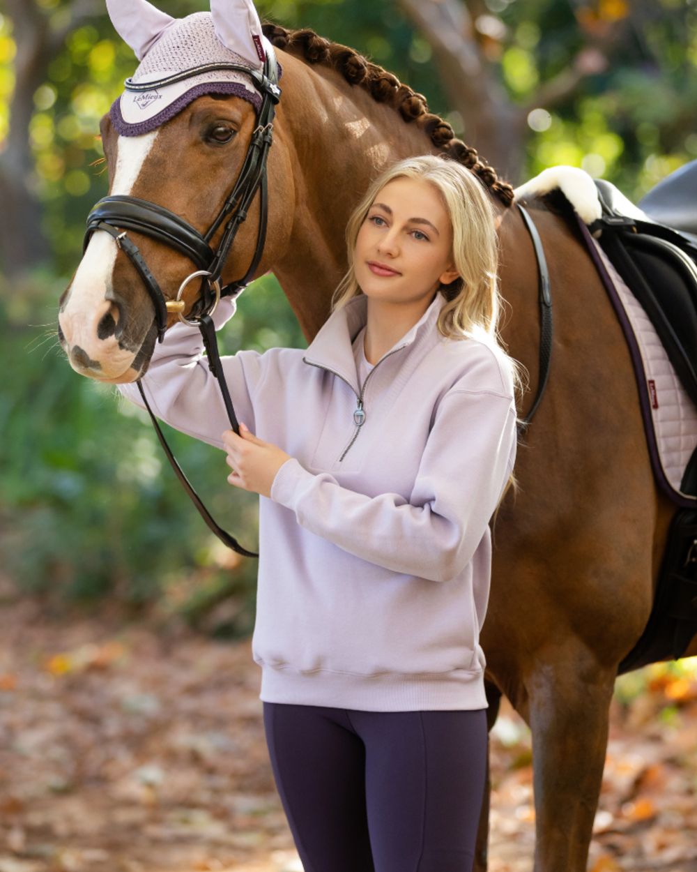 Lilac coloured LeMieux Womens Keira Quarter Neck Sweatshirt on forest background 