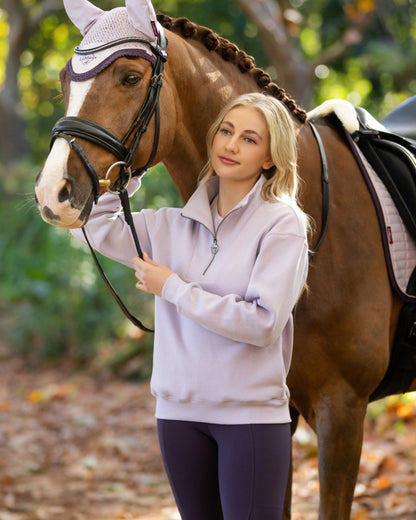 Lilac coloured LeMieux Womens Keira Quarter Neck Sweatshirt on forest background 