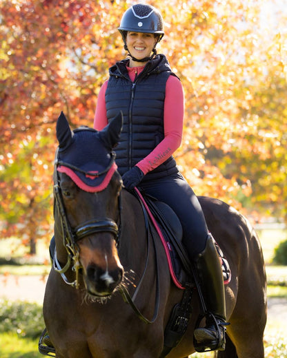 Navy coloured LeMieux Womens Rose Hooded Puffer Gilet on garden background 