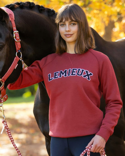 Russet coloured LeMieux Womens Vida Varsity Crew Neck Sweatshirt on outdoor background 