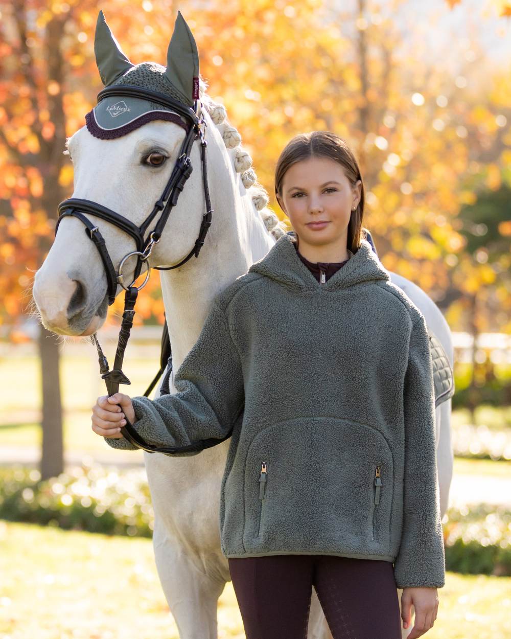 Rosemary coloured LeMieux Young Rider Avalon Hoodie on tree background 
