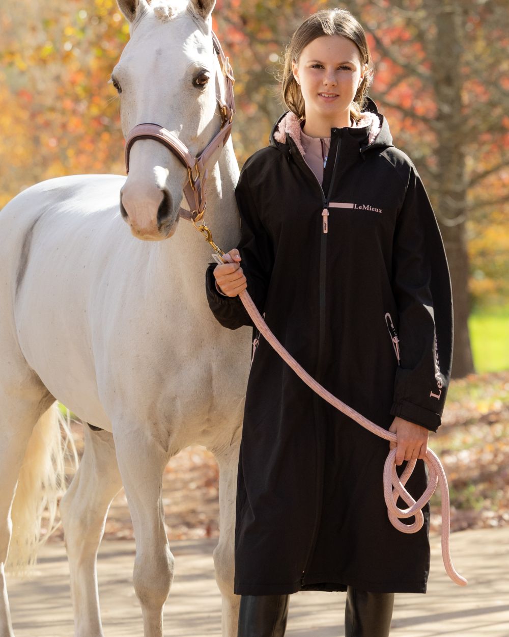 Black coloured LeMieux Young Rider HydroShield Robe Long Coat on outdoor background 
