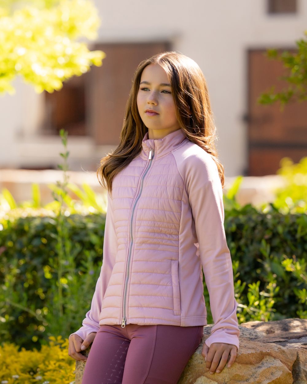 Blossom coloured LeMieux Young Rider Josephine Jacket on backyard background 