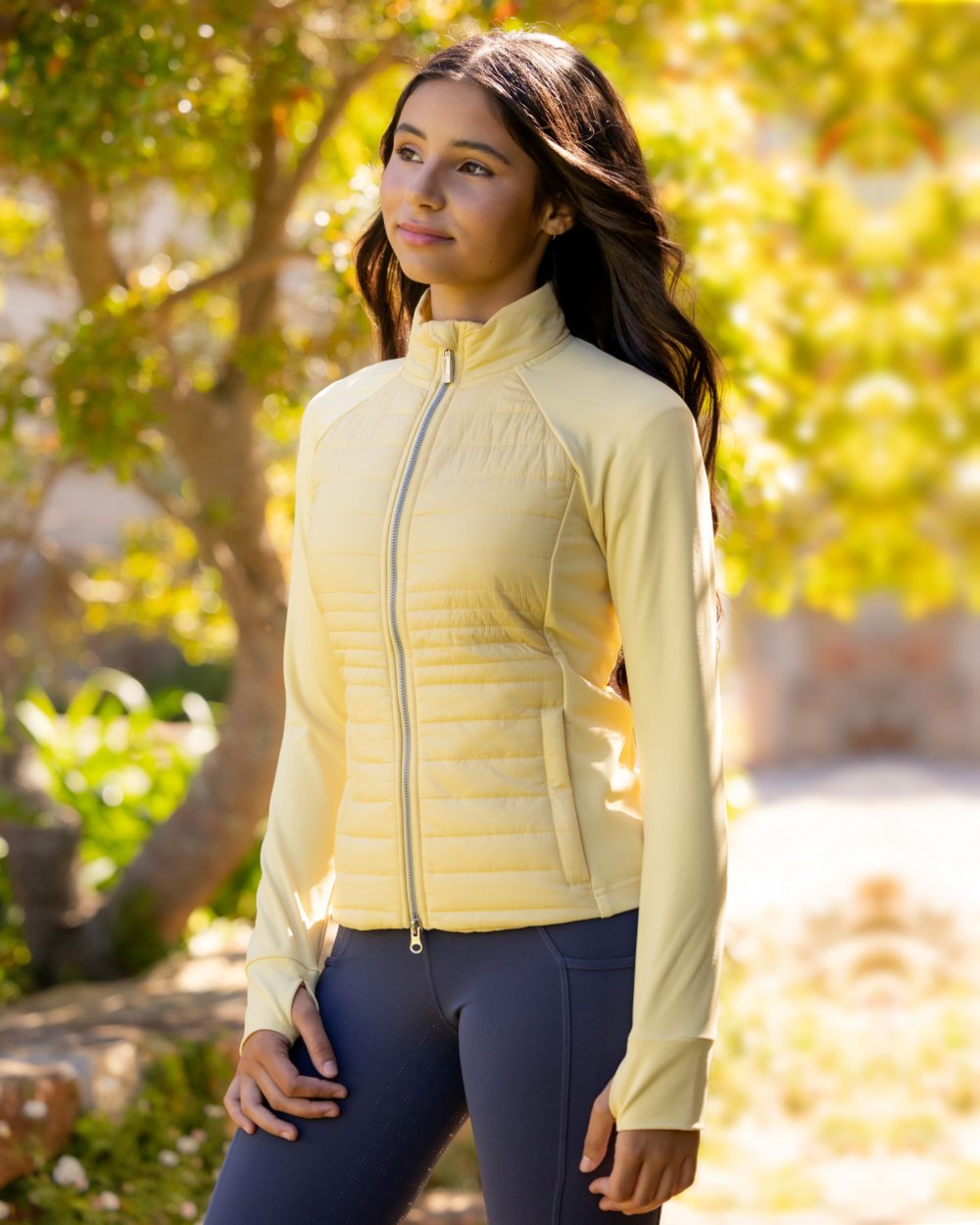 Mimosa coloured LeMieux Young Rider Josephine Jacket on backyard background 