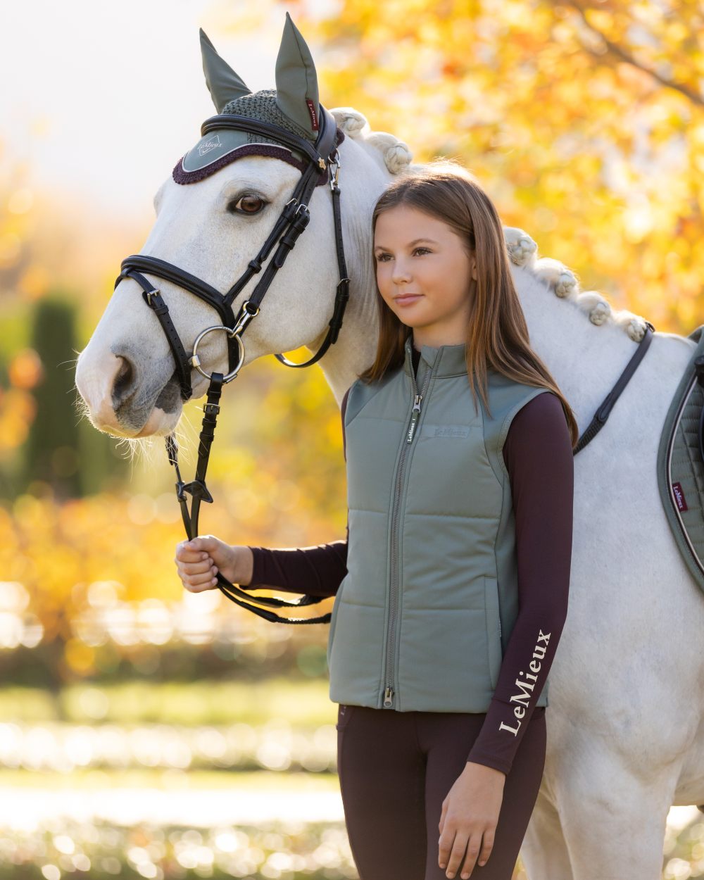 Rosemary coloured LeMieux Young Rider Pammy Training Gilet on tree background 