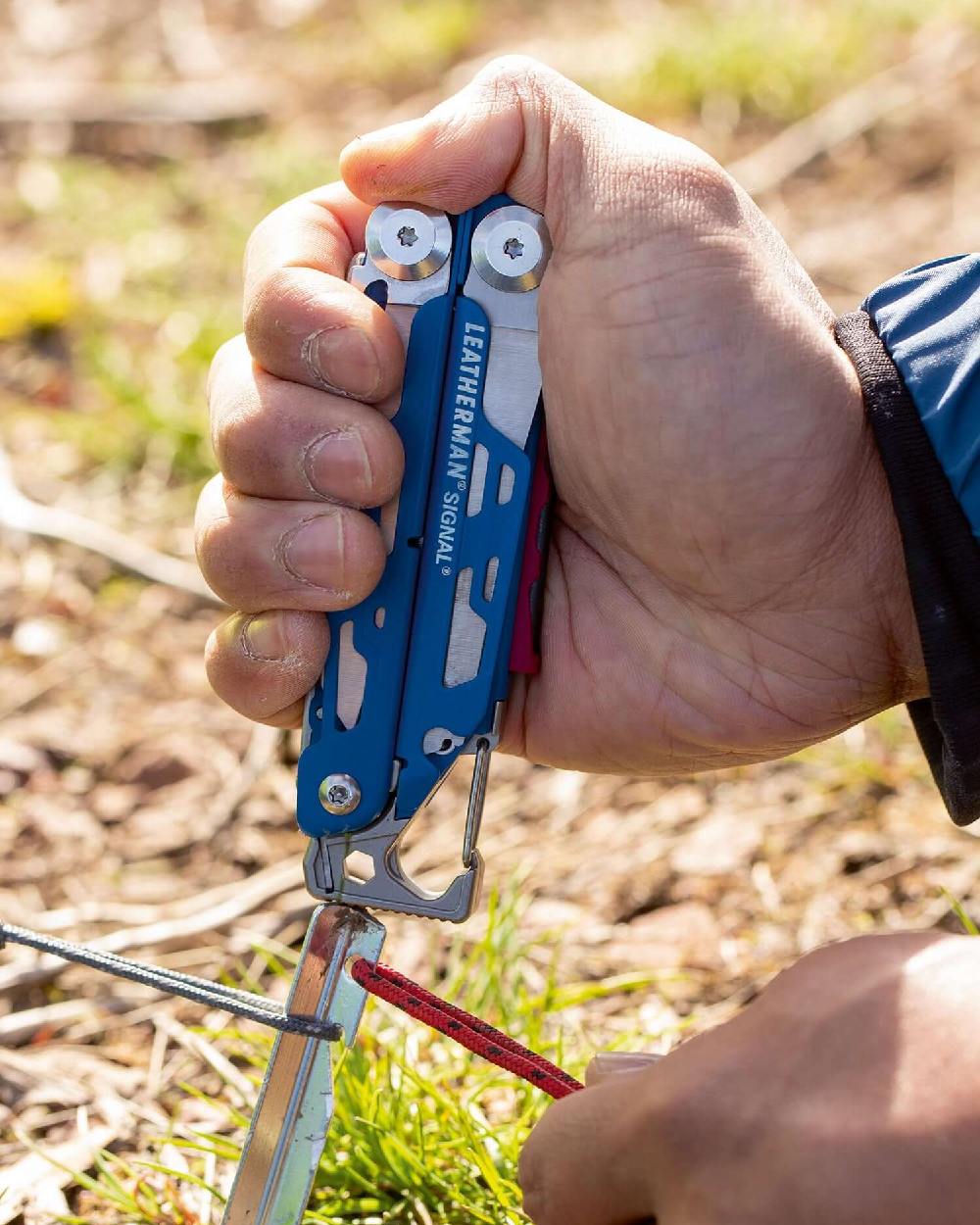 Blue Cerakote Coloured Leatherman Signal+ Multi-Tool W/ Nylon Sheath On A Forest Background 