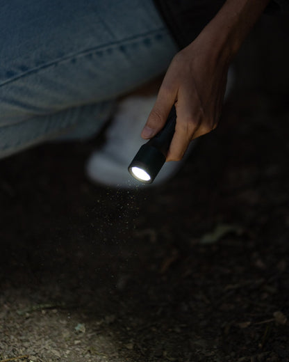 Black coloured Led Lenser P5R Core Rechargeable Torch on street background 